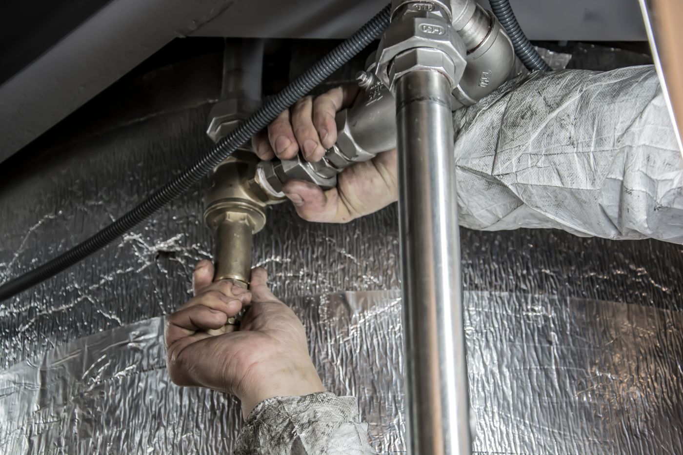 Plumber inspecting a residential water heater in Overland Park, Kansas